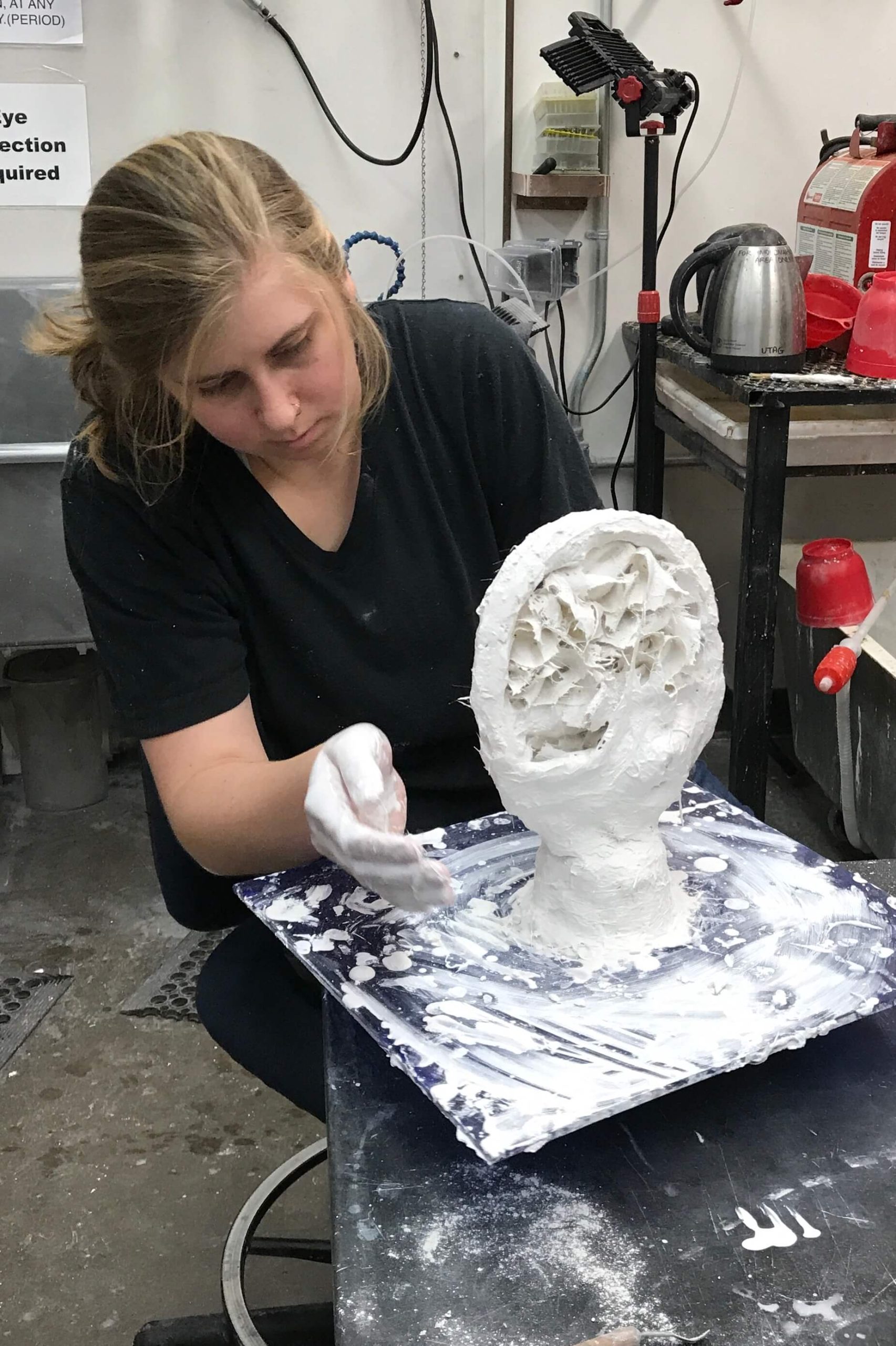Artist sculpting in a workshop.