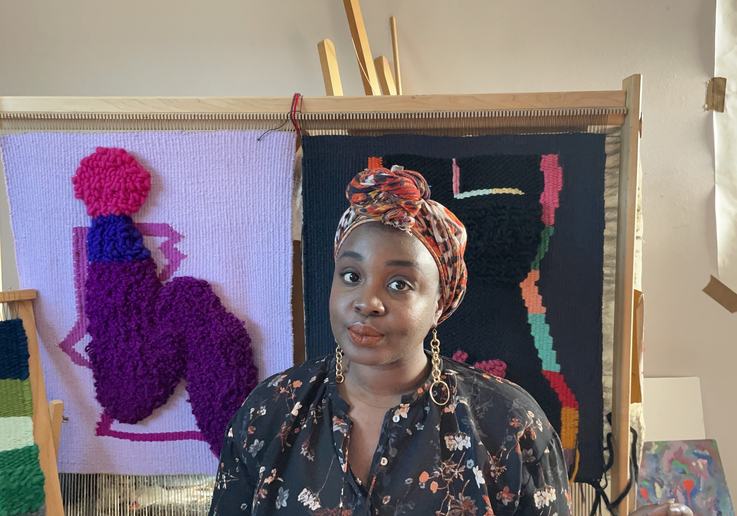 Artist standing in front of colorful art.